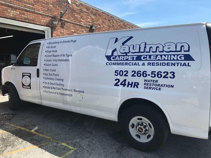 A white Kaufman Carpet Cleaning van lettered with the company's services and phone number